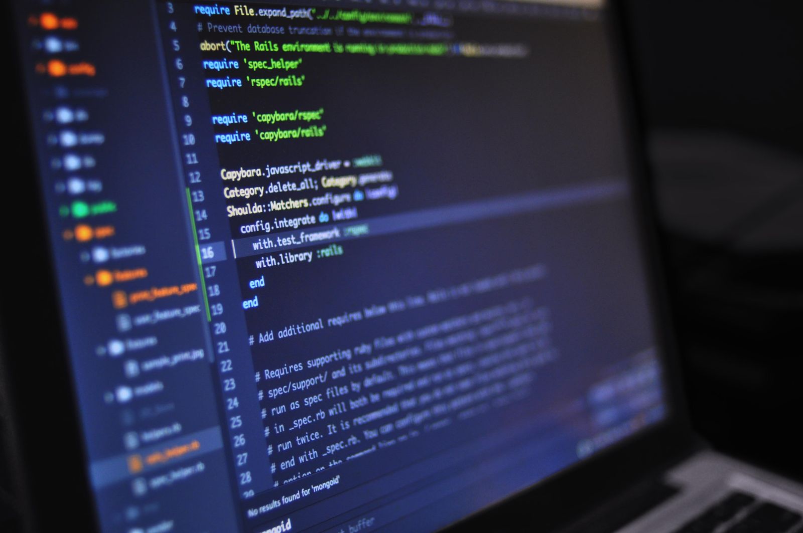 Close-up of a monitor showing source code in a dark editor